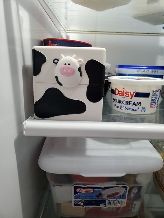 the cow-shaped container sitting on a fridge shelf