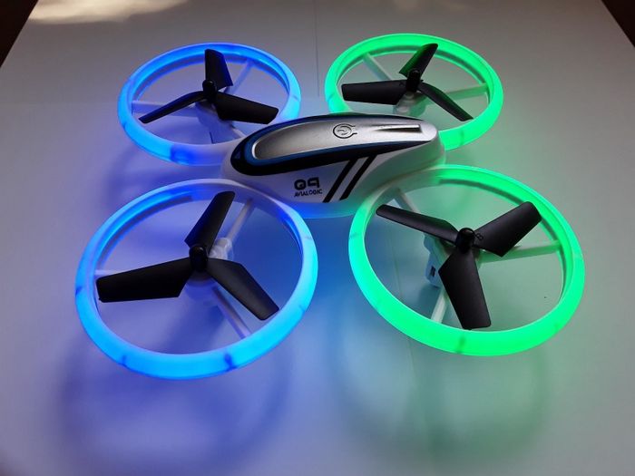 A reviewer's photo of a green and blue LED-lit drone.