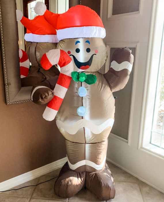 A reviewer's photo of the inflatable gingerbread figure placed by their front door inside their home