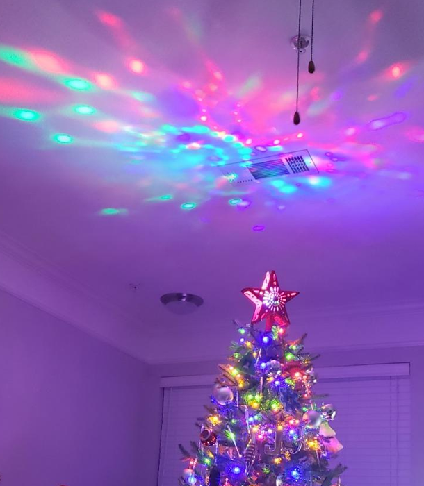 reviewer photo showing the star topper casting colorful lights onto their ceiling