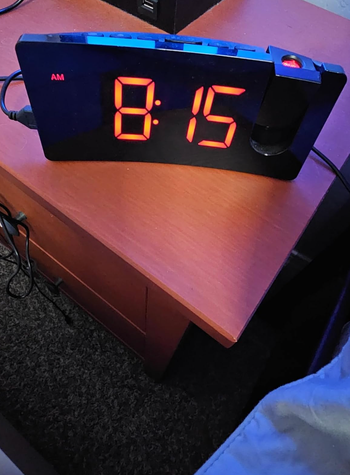A digital alarm clock showing 8:15 on a bedside table.