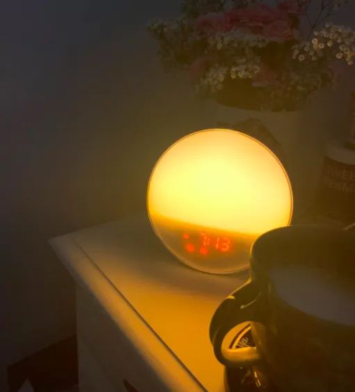 A customer review photo of the sunrise alarm clock beautifully placed on their nightstand, ready to greet the morning.