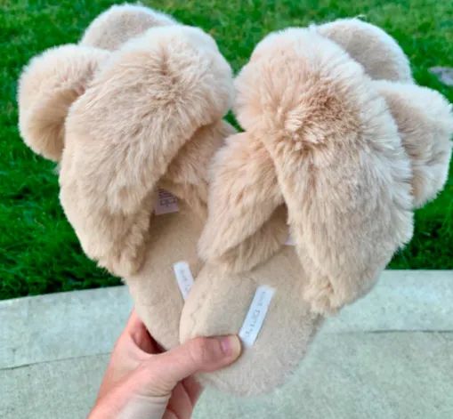 A customer review photo of someone holding the fluffy slippers.