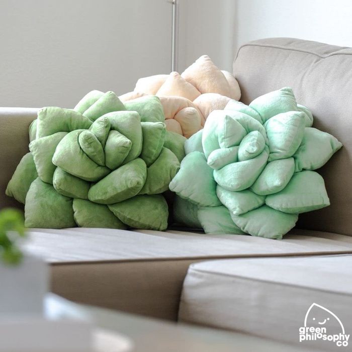 three succulent pillows arranged on a couch
