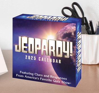 The Jeopardy! 2025 calendar featuring quiz show clues and answers, placed on a desk beside a holder with scissors.