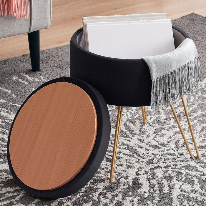 A black velvet ottoman with gold hairpin legs, featuring a removable lid for added functionality.