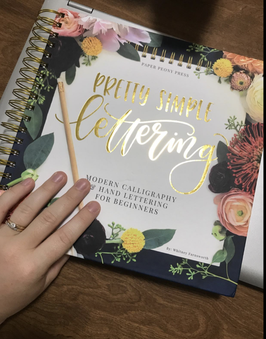 A reviewer holding the spiral-bound book on a table.