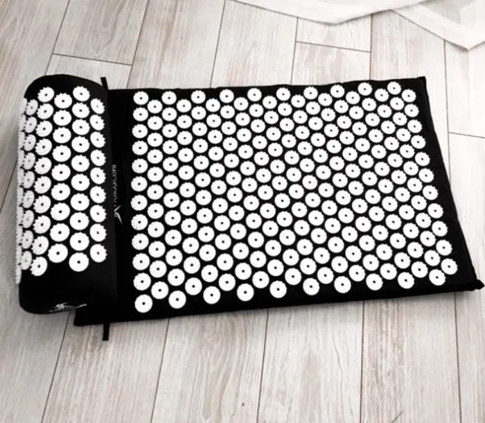 A customer review photo showcasing the acupressure mat and pillow set.