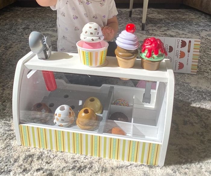 A reviewer's child enjoying time at the ice cream counter, playing with the set.