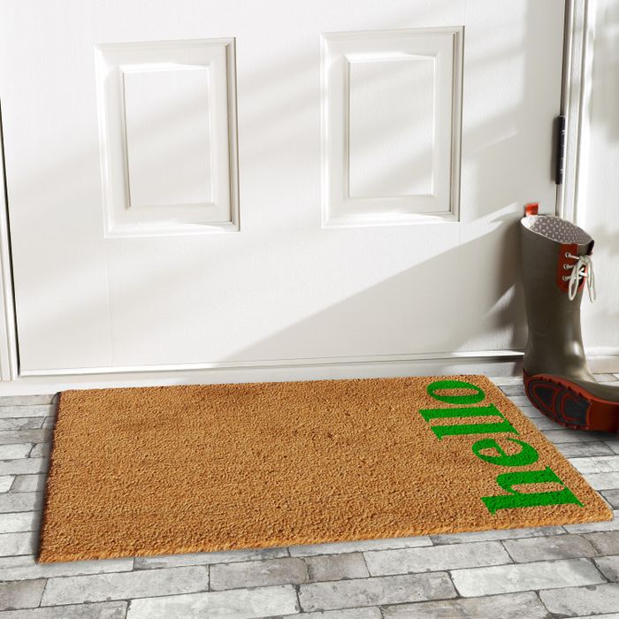 A coir doormat with a cheerful 'hello' in green lettering.