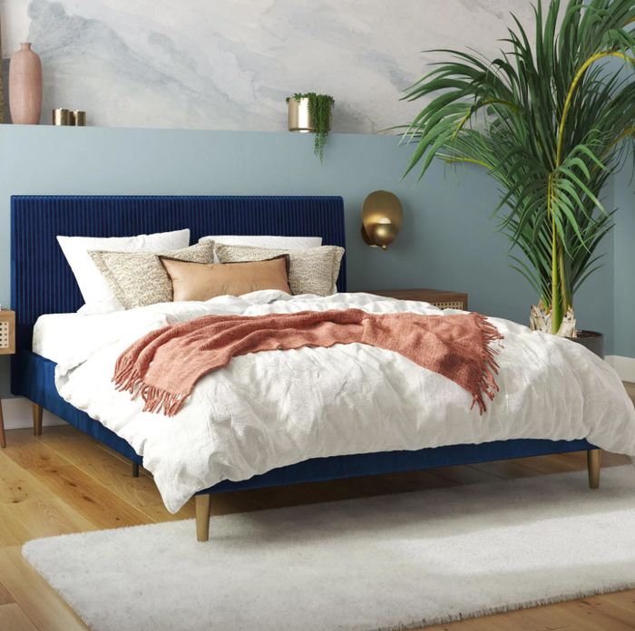 Luxurious blue velvet bedframe with a matching headboard