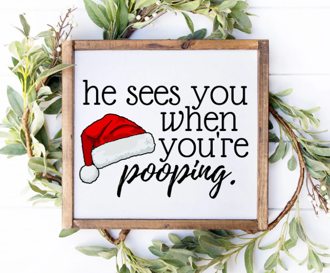 A framed sign featuring a Santa hat with the text 