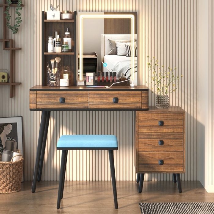 Wooden vanity with shelves, a mirror, and a blue stool, showcasing makeup and skincare products in a chic modern bedroom