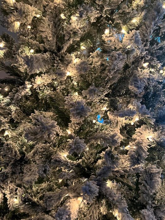 a close-up of a reviewer’s Christmas tree branches, beautifully covered in soft, snow-like flocking