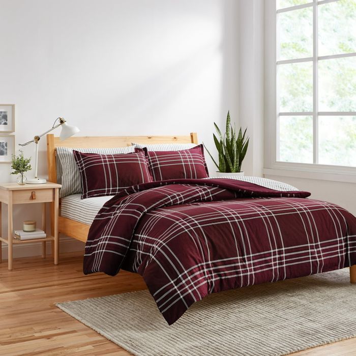 A red and white plaid comforter and matching shams, adding a cozy and festive touch to your bed.