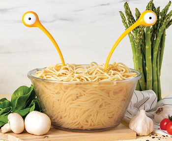 The utensils sticking out of a bowl of pasta
