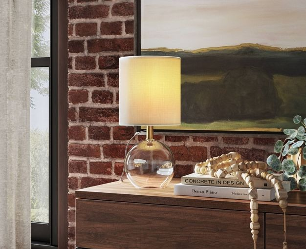 The lamp is switched on, gracefully resting on a table, casting a gentle light.