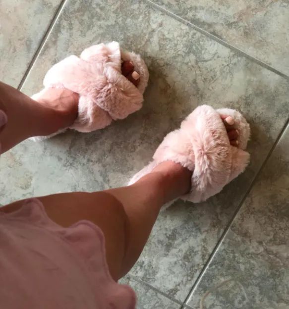 A customer review photo showing someone wearing the comfy slippers.