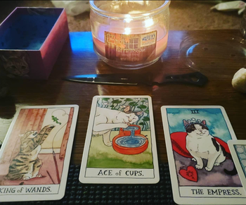 Three illustrated tarot cards arranged for a reading