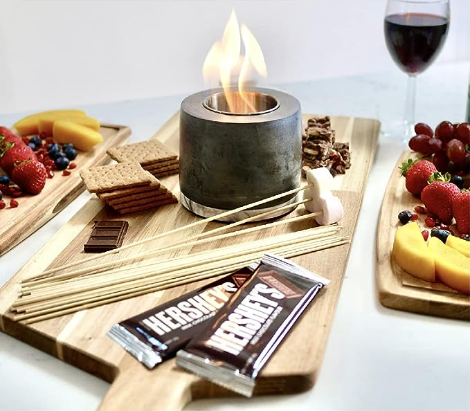 A plate with s'mores ingredients next to the fire pit