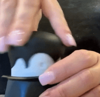 A reviewer twisting a garlic crusher shaped like a vampire and revealing the garlic inside