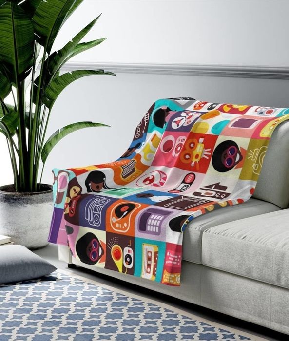 A blanket featuring a tech-inspired design with motifs of music, cell phones, and other elements