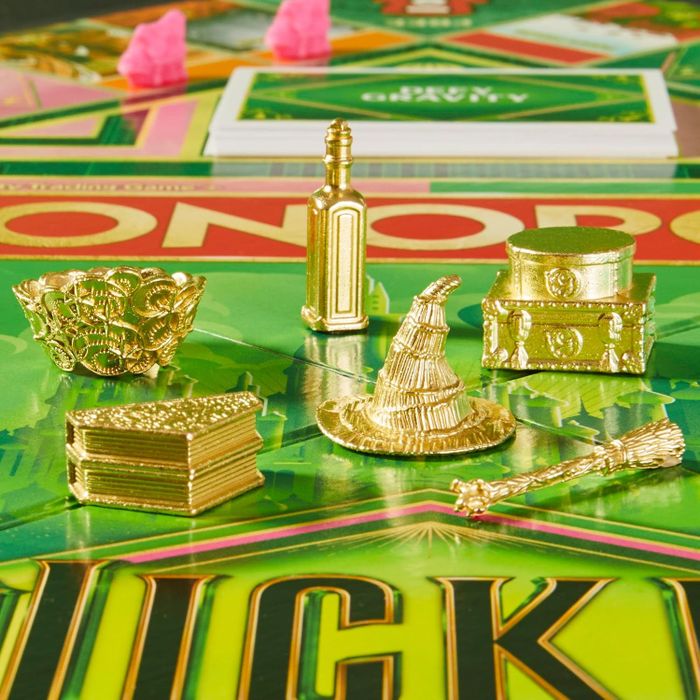 Monopoly game pieces designed with a Harry Potter theme, including a wizard's hat, a cauldron, and a spellbook, placed on the board.