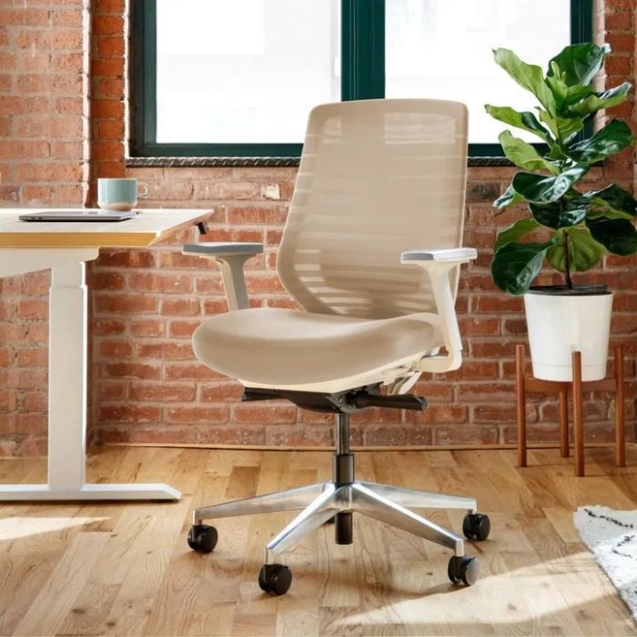 Ergonomic office chair featuring a mesh backrest and adjustable armrests, set in a modern home office environment