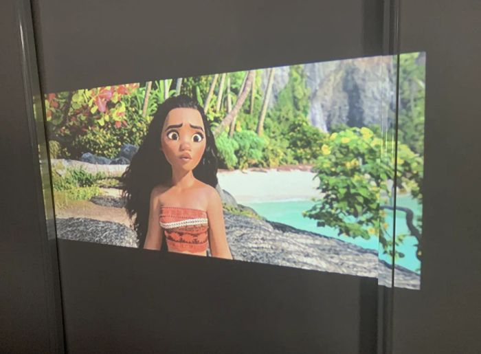 A customer review photo showcasing a movie being projected onto their wall using the projector.