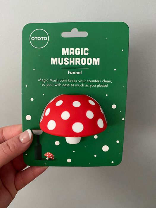 A hand holding the compact funnel in its packaging 