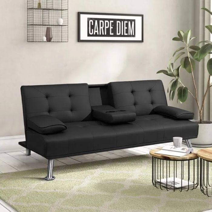 A black futon sofa with adjustable backrests and armrests in a modern living room, featuring a 