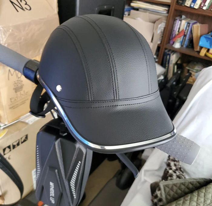 A customer review photo showing the helmet resting on the handlebars of their scooter