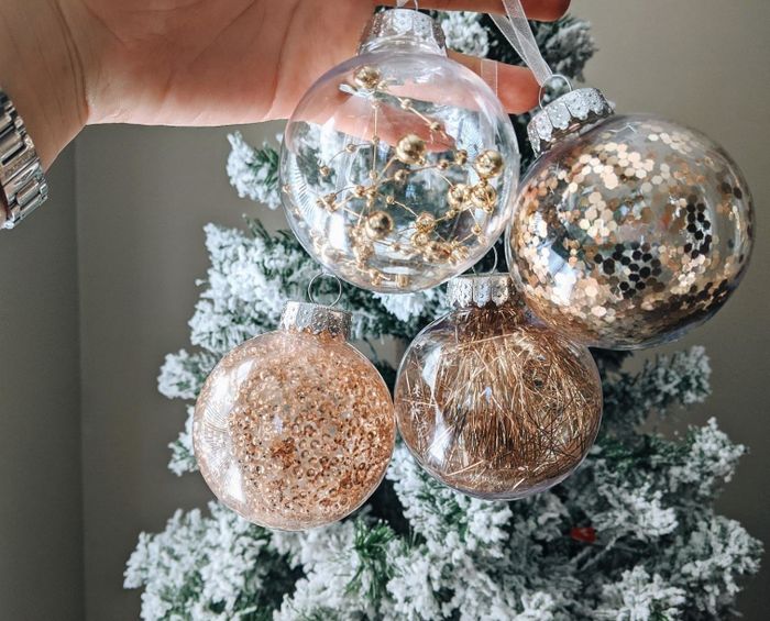 Reviewer photo showing four gold ball ornaments displayed in front of a decorated Christmas tree