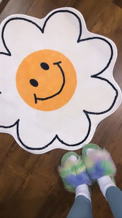 a reviewer’s flower-shaped rug featuring a smiley face design in the center