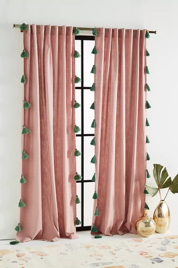 pink curtains adorned with blue tassel trim