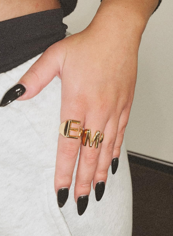A hand adorned with gold jewelry.