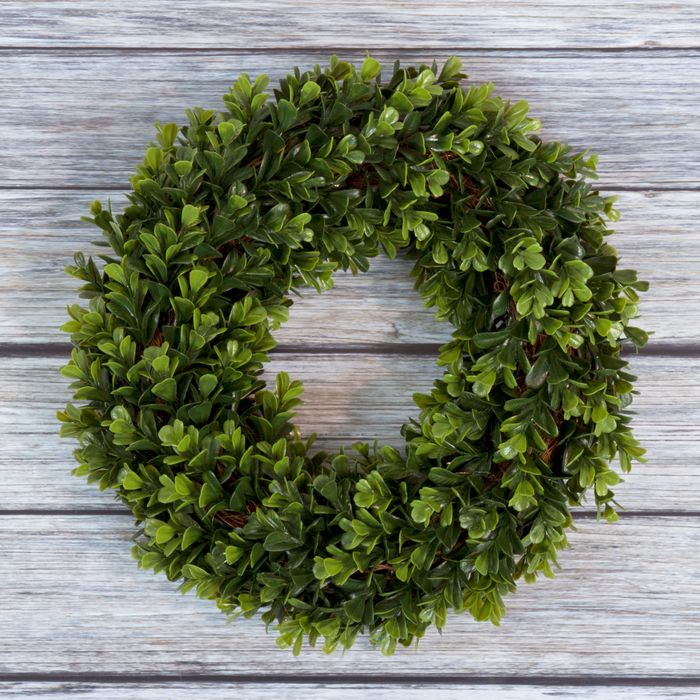 The wreath beautifully displayed against a wooden backdrop.