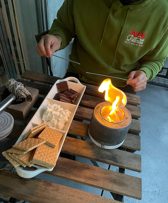 A reviewer's photo featuring a plate of graham crackers, marshmallows, and chocolate placed beside the fire pit for making s'mores