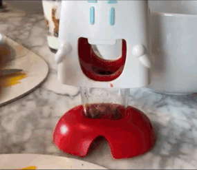 A gif showing a reviewer using the cherry pitter, demonstrating how effortlessly it works.
