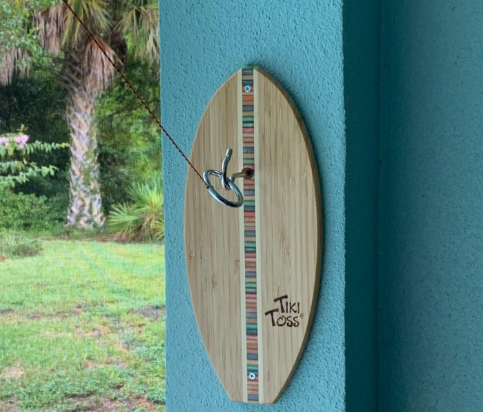 A photo from a reviewer showing the Tiki Toss game mounted on a wall outside.