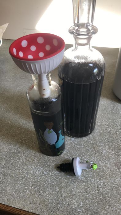 A reviewer using the funnel to pour wine 