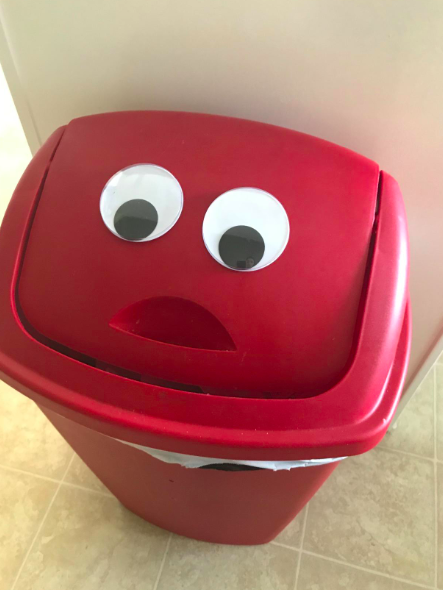 A trashcan with large googly eyes that adds a quirky touch to any room.