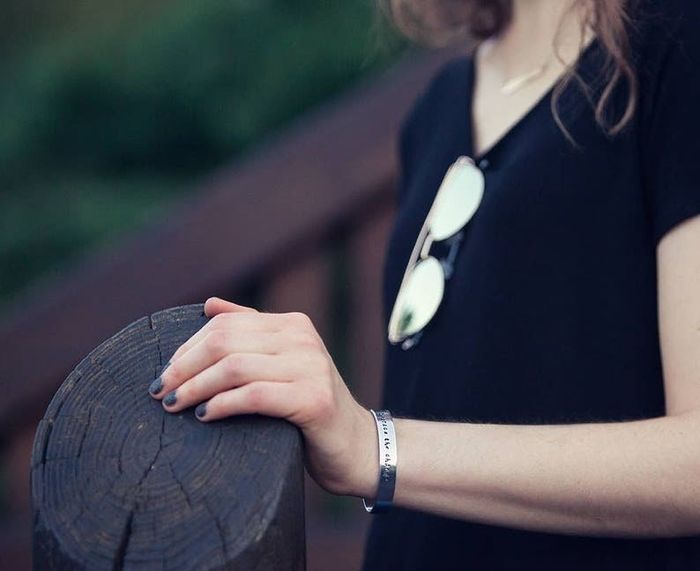 Model showcasing a silver binary code bracelet worn on her wrist