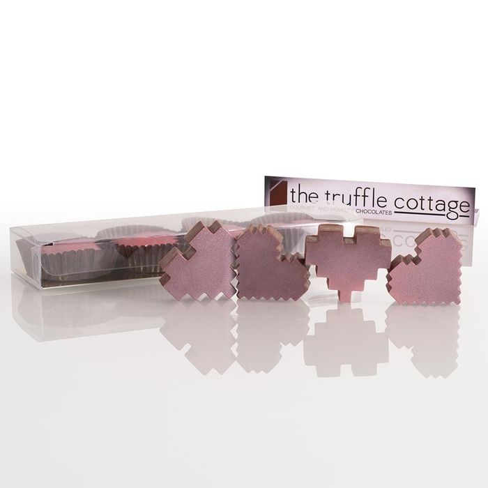 Box filled with pink truffles shaped like pixelated hearts