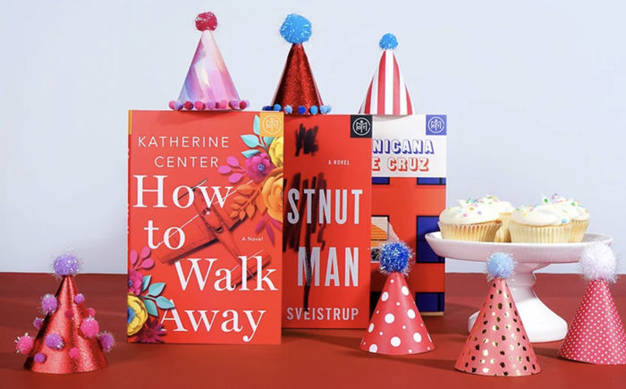 three books adorned with birthday hats