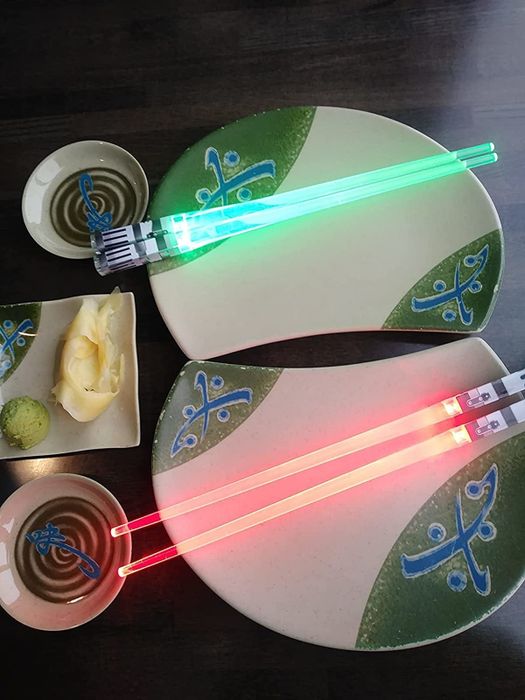 A reviewer photo showing two pairs of lightsaber chopsticks, one red and one green.