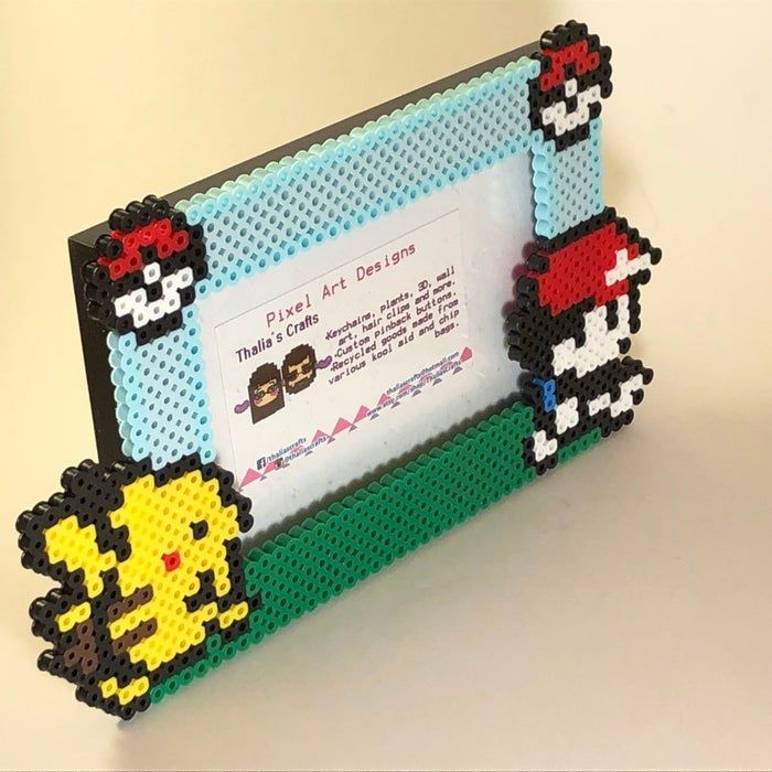 A bead art photo frame inspired by Pokémon, featuring Pikachu, Poké Balls, and a character similar to Ash Ketchum. The center includes an advertisement for 