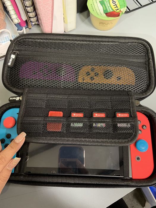 photo from a reviewer showing a red and blue Nintendo Switch inside the case, with a pocket for game cartridges