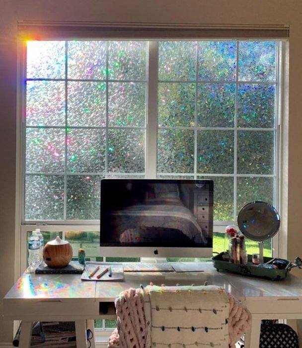 The reviewer’s work desk with prismatic window film applied, casting vibrant rainbows across the desk area