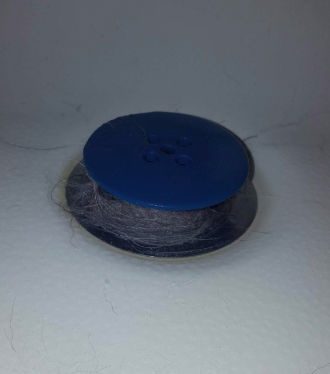 A reviewer's image of the TubShroom in a shower drain, slightly raised above the surface